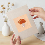 Hand holding a finished Acorn and Mushroom mini canvas
