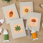The four finished Acorn and Mushroom mini canvases laid out on a table