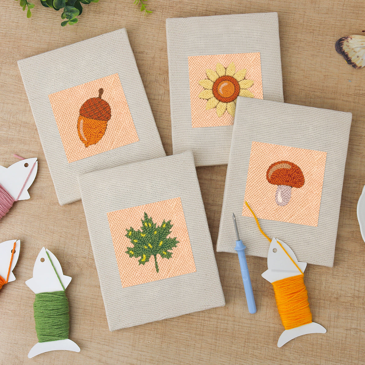 The four finished Acorn and Mushroom mini canvases laid out on a table
