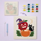 Apple Cauldron Cat canvas before and after punching, with the threads and tools