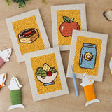 The four finished Apple Salad Jar mini canvases laid out on a table