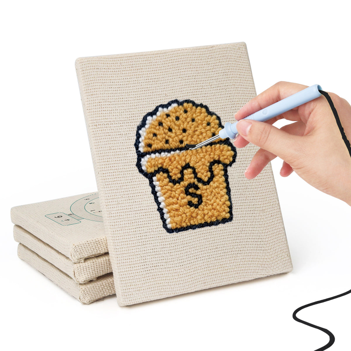 Hand punching one of the Bakery Treats mini canvases