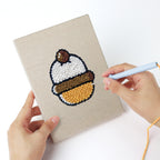 Punching a Bakery Treats mini canvas with the punch needle