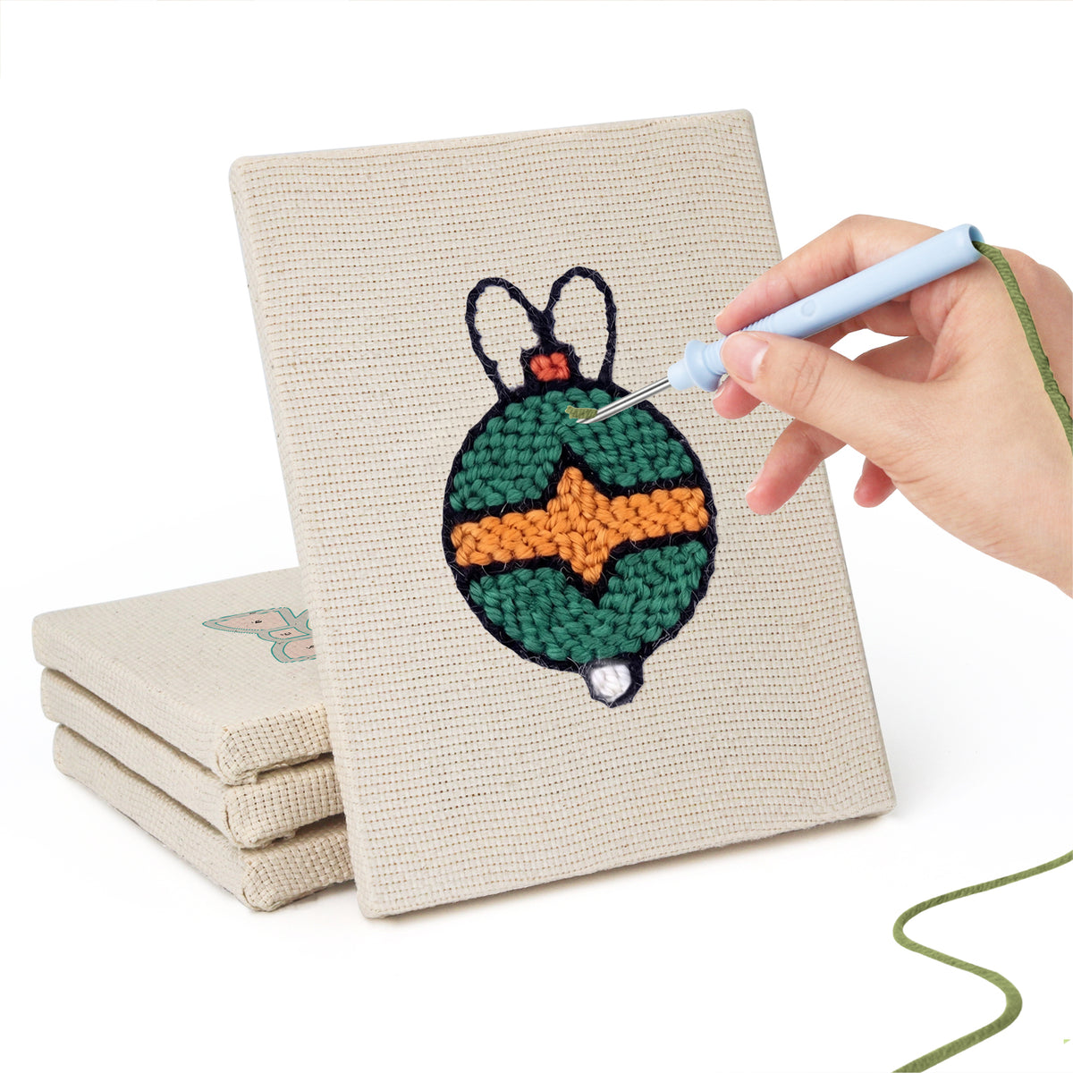 Hand punching one of the Bauble and Snowflake mini canvases