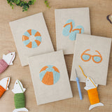 The four finished Beach Day Essentials mini canvases laid out on a table