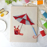 Beach Umbrella Day canvas before and after punching, with the threads and tools