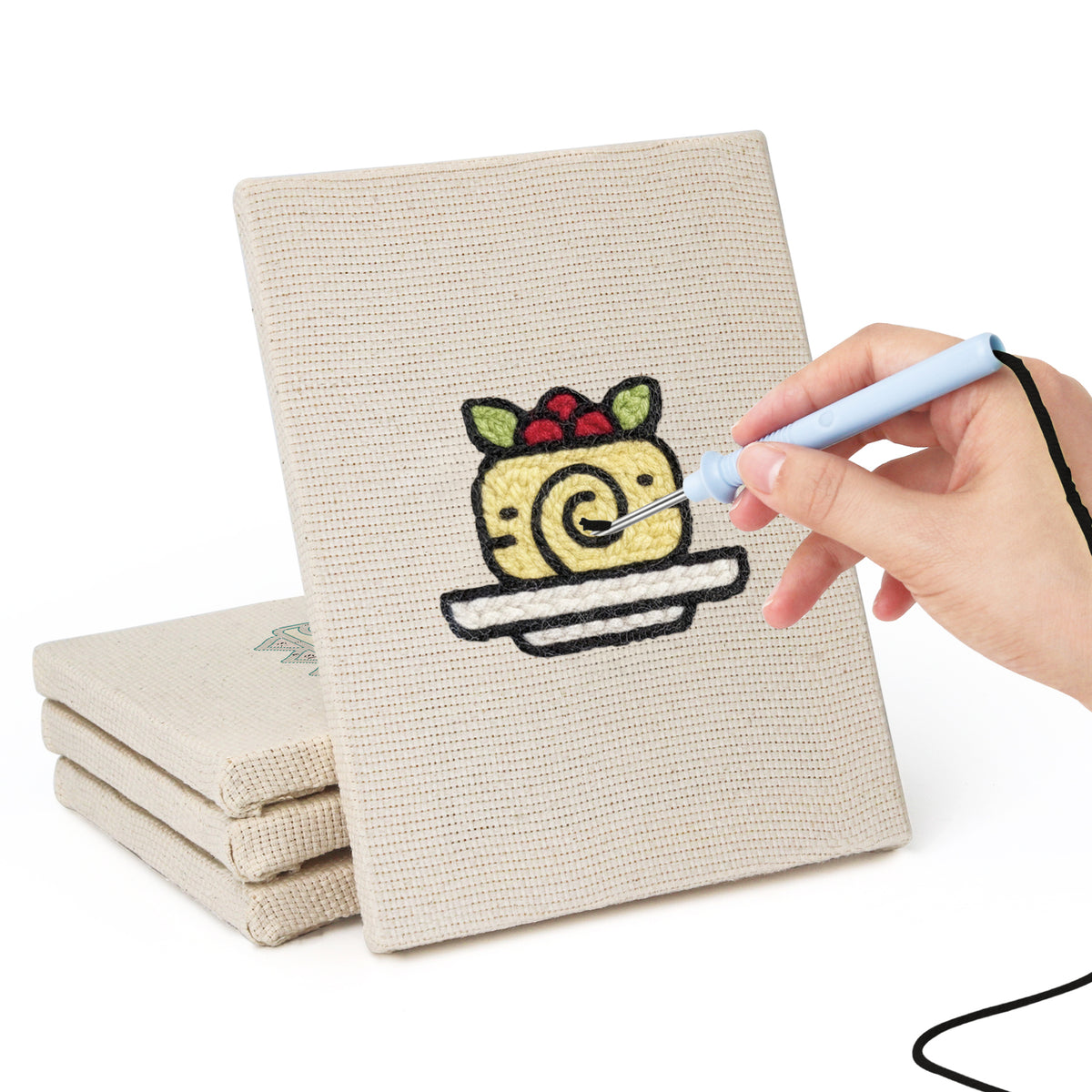Hand punching one of the Berry Roll Cake mini canvases