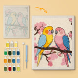 Blossom Branch Parrots canvas before and after punching, with the threads and tools