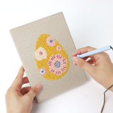 Punching a Blue Bloom Eggs mini canvas with the punch needle