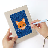 Punching a Blue Cat Portraits mini canvas with the punch needle