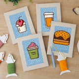 The four finished Blue Cherry Cupcake mini canvases laid out on a table