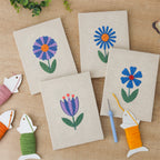 The four finished Blue Garden Blooms mini canvases laid out on a table