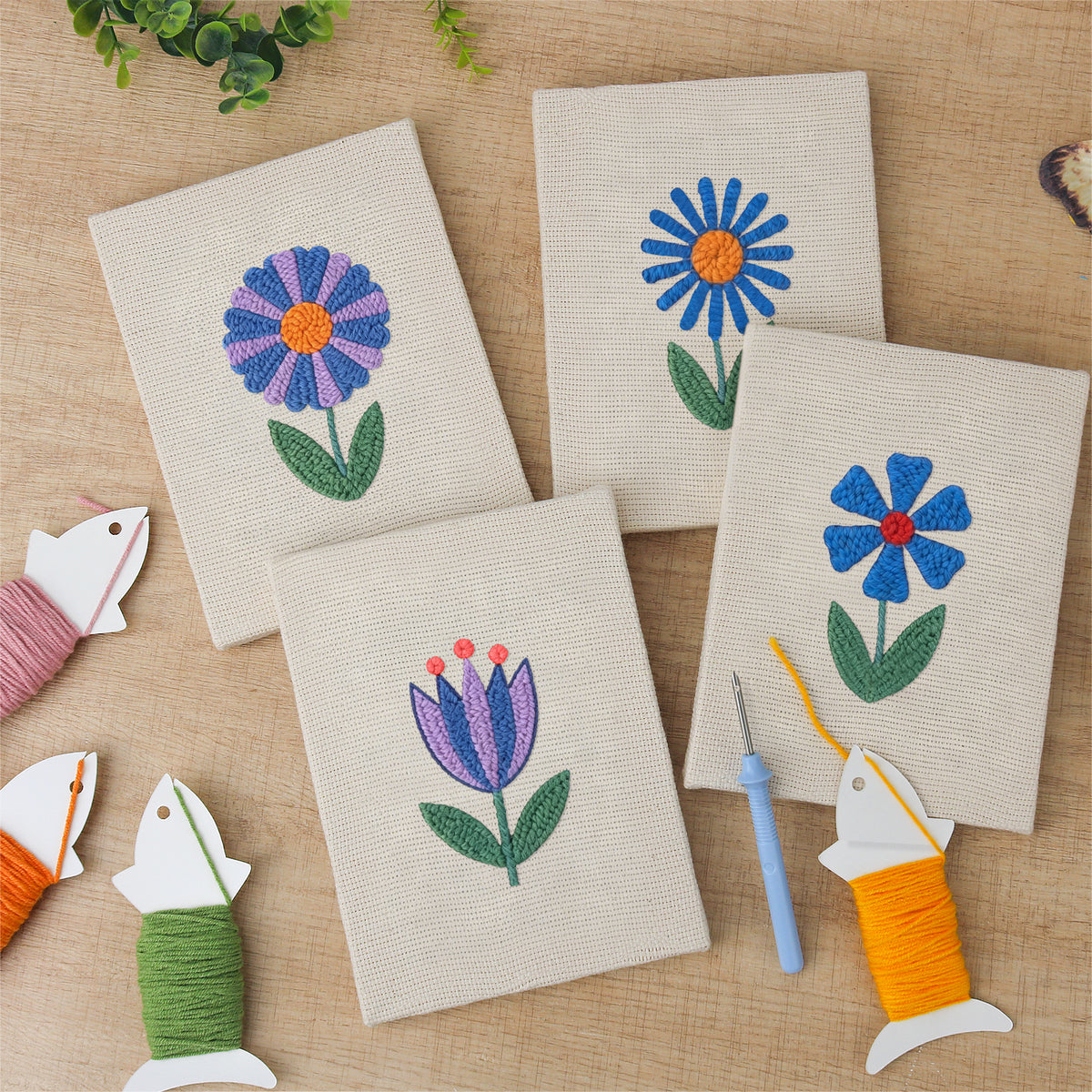 The four finished Blue Garden Blooms mini canvases laid out on a table