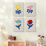 The four Blue Leaf Flowers mini canvases on a wall above a shelf