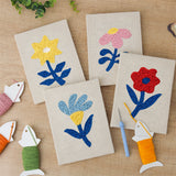 The four finished Blue Leaf Flowers mini canvases laid out on a table