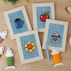 The four finished Blue Mug Morning mini canvases laid out on a table