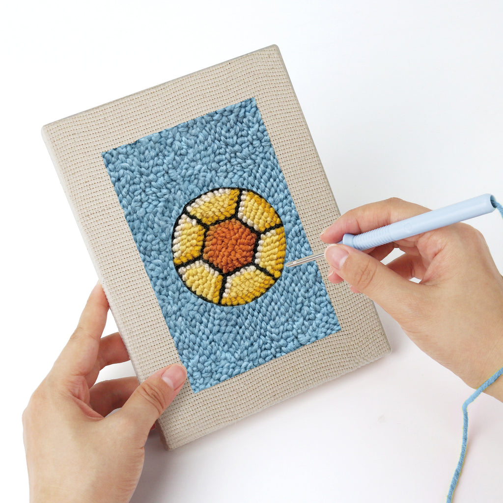 Punching a Blue Mug Morning mini canvas with the punch needle