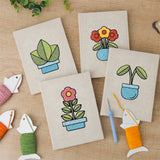 The four finished Blue Planter Blooms mini canvases laid out on a table