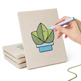 Hand punching one of the Blue Planter Blooms mini canvases