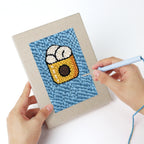 Punching a Blue Plate Snacks mini canvas with the punch needle