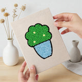 Hand holding a finished Blue Pot Greens mini canvas