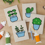 The four finished Blue Pot Greens mini canvases laid out on a table