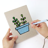Punching a Blue Pot Greens mini canvas with the punch needle