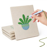 Hand punching one of the Blue Pot Houseplants mini canvases