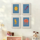 The four Blue Sea Friends mini canvases on a wall above a shelf
