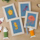 The four finished Blue Sea Friends mini canvases laid out on a table