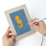 Punching a Blue Sea Friends mini canvas with the punch needle
