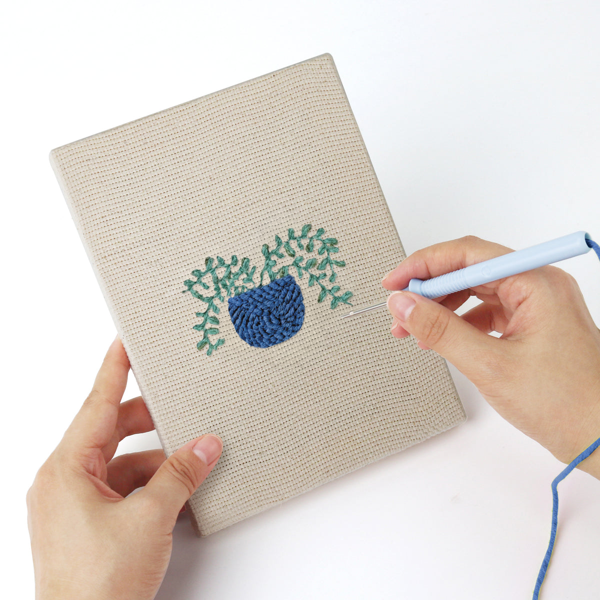 Punching a Blue Yellow Planters mini canvas with the punch needle