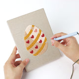Punching a Blush Easter Eggs mini canvas with the punch needle