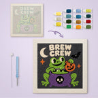 Brew Crew Frog canvas before and after punching, with the threads and tools