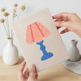 Hand holding a finished Bright Retro Lamps mini canvas