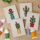 The four finished Bright Vase Plants mini canvases laid out on a table