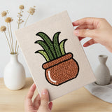 Hand holding a finished Brown Pot Blooms mini canvas