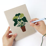 Punching a Brown Pot Jungle mini canvas with the punch needle