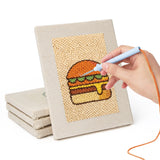 Hand punching one of the Burger and Donut mini canvases