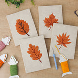 The four finished Burnt Orange Leaves mini canvases laid out on a table
