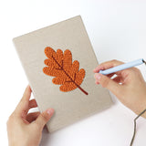 Punching a Burnt Orange Leaves mini canvas with the punch needle