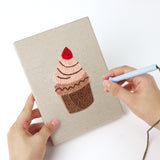 Punching a Cafe Sweet Treats mini canvas with the punch needle