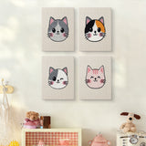 The four Calico Cat Faces mini canvases on a wall above a shelf