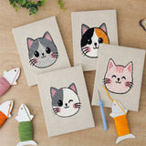The four finished Calico Cat Faces mini canvases laid out on a table