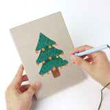 Punching a Candy Cane Bow mini canvas with the punch needle