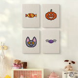 The four Candy Pumpkin Cat mini canvases on a wall above a shelf