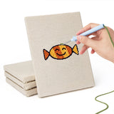 Hand punching one of the Candy Pumpkin Cat mini canvases