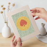 Hand holding a finished Card Suit Circles mini canvas