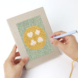 Punching a Card Suit Circles mini canvas with the punch needle