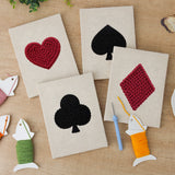 The four finished Card Suits mini canvases laid out on a table